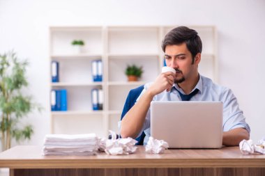 Genç bir erkek çalışan ofiste yeni fikirleri reddediyor.