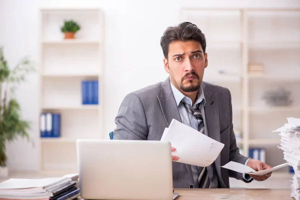 Junge männliche Angestellte unzufrieden mit exzessiver Arbeit im Büro — Stockfoto