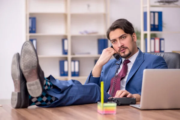 Jovem trabalhador masculino sentado no local de trabalho — Fotografia de Stock