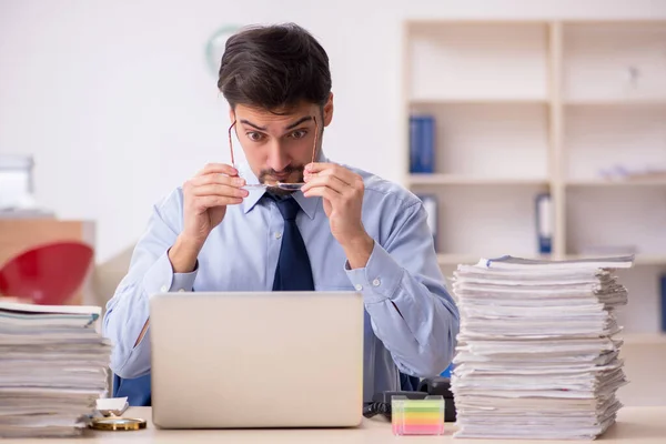 Junge männliche Mitarbeiter und zu viel Arbeit im Büro — Stockfoto