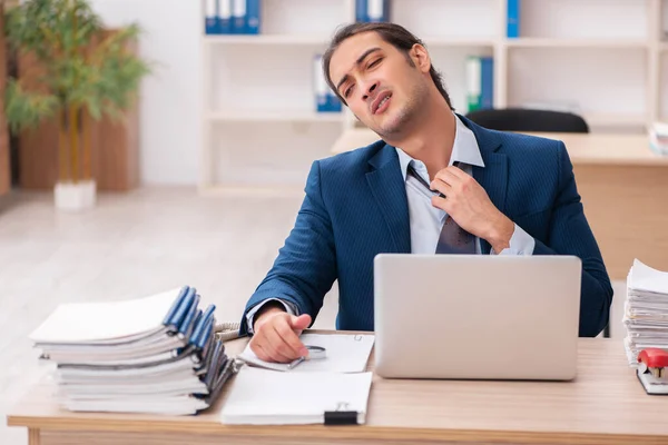 Jovem funcionário do sexo masculino infeliz com trabalho excessivo — Fotografia de Stock