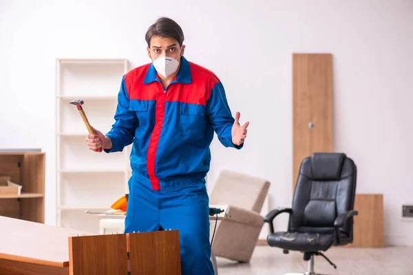 Joven carpintero masculino trabajando en la oficina durante una pandemia — Foto de Stock