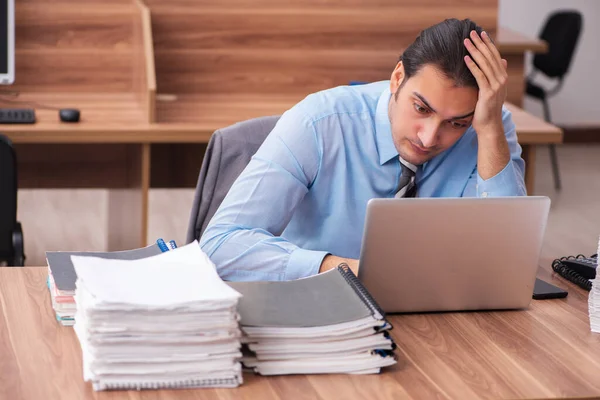 Jonge mannelijke werknemer ongelukkig met overmatig werk — Stockfoto