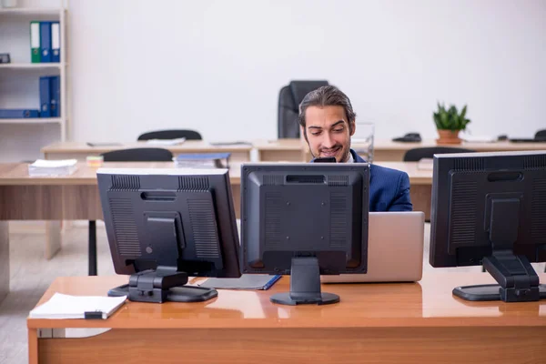 Mladý muž zaměstnanec v konceptu multitasking — Stock fotografie