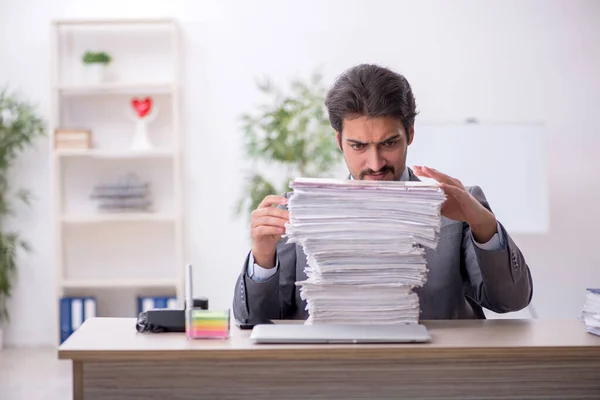 Junge männliche Mitarbeiter und zu viel Arbeit im Büro — Stockfoto