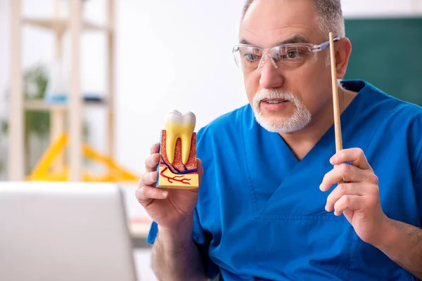 Viejo doctor dentista masculino en concepto de telestudying — Foto de Stock