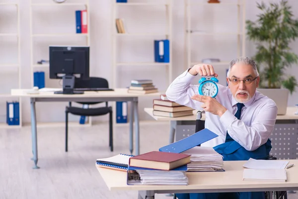 Gammal manlig anställd i rullstol i time management koncept — Stockfoto