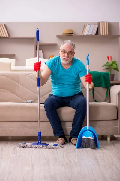 Oude man die het huis schoonmaakt — Stockfoto