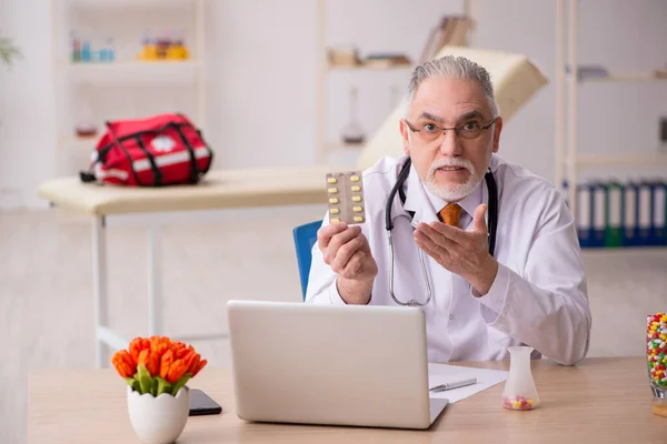 Old male doctor pharmacist working in the clinic — Stock Photo, Image