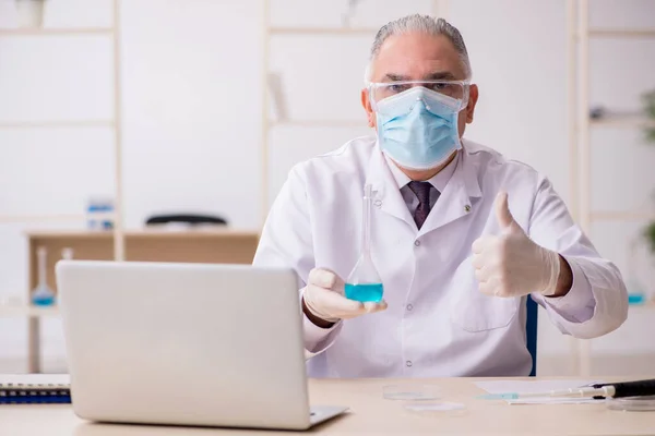 Oude mannelijke chemicus werkt in het lab tijdens een pandemie — Stockfoto