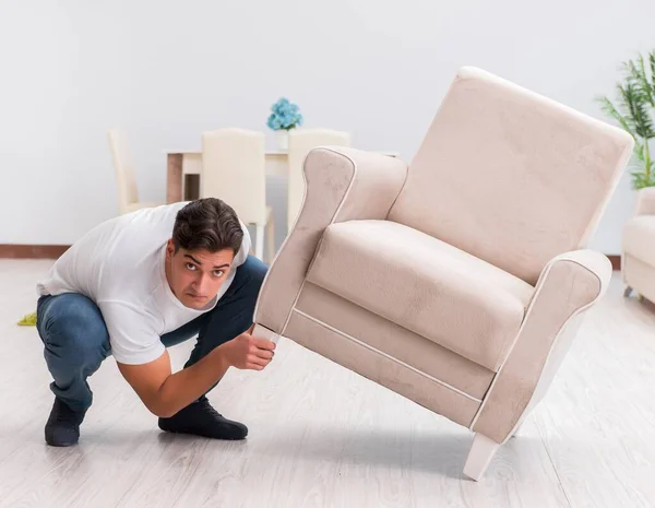 Man moving furniture at home