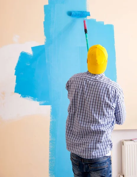 Pittore uomo pittura il muro a casa — Foto Stock