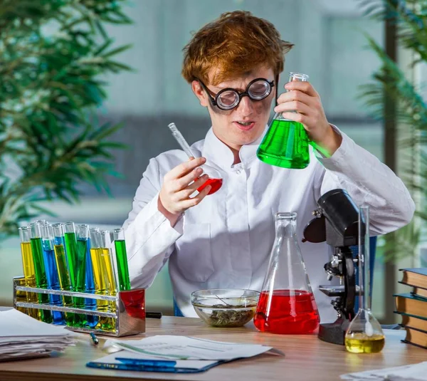 Молодой сумасшедший химик работает в лаборатории — стоковое фото