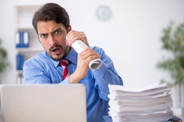 Jovem funcionário masculino infeliz com excesso de trabalho no escritório — Fotografia de Stock