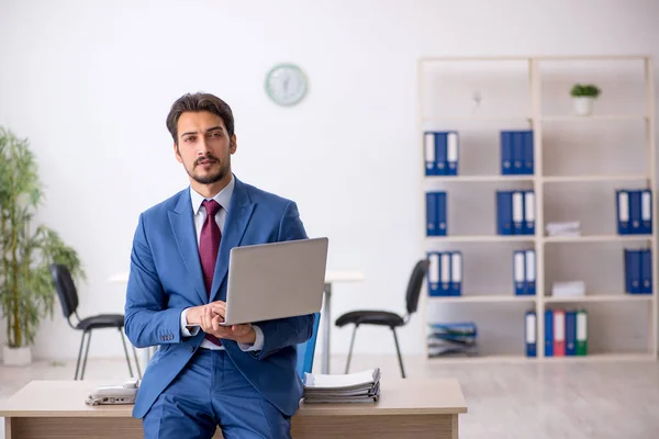 Jonge mannelijke werknemer die op de werkplek werkt — Stockfoto