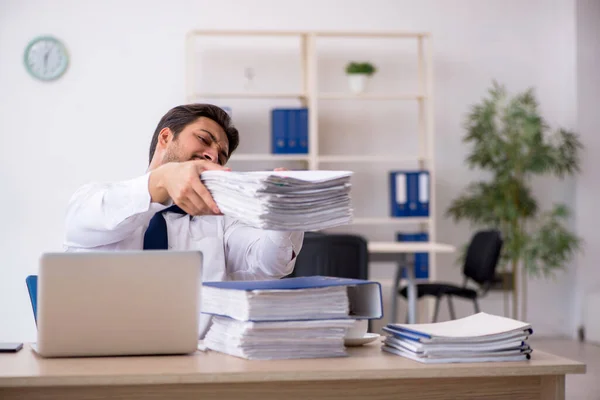 Young male employee unhappy with excessive work in the office — Stock Photo, Image