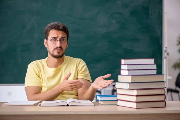 Jonge mannelijke student bereidt zich voor op examens in de klas — Stockfoto