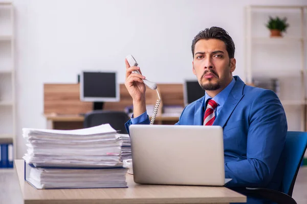 Joven empleado descontento con el trabajo excesivo en el lugar de trabajo —  Fotos de Stock