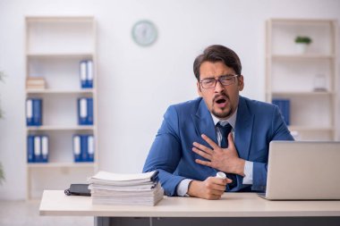 İş yerinde acı çeken genç bir erkek işçi.