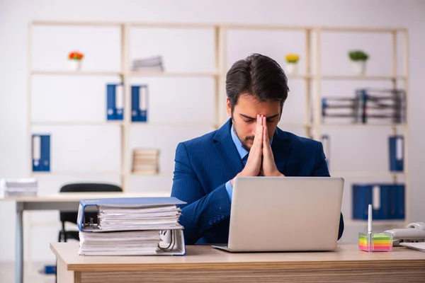 Empleado joven sentado en el lugar de trabajo — Foto de Stock