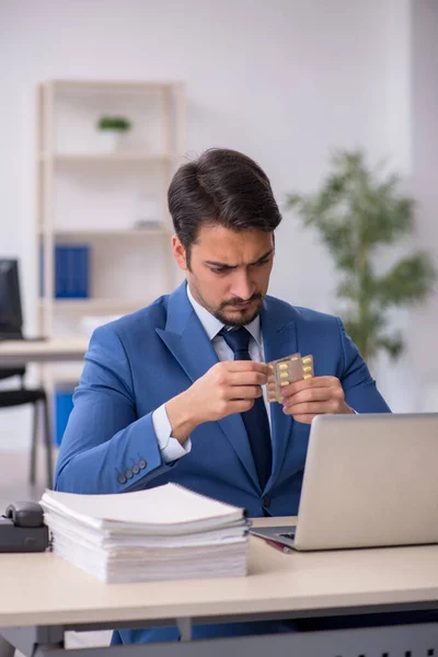 Giovane dipendente maschile che soffre sul posto di lavoro — Foto Stock