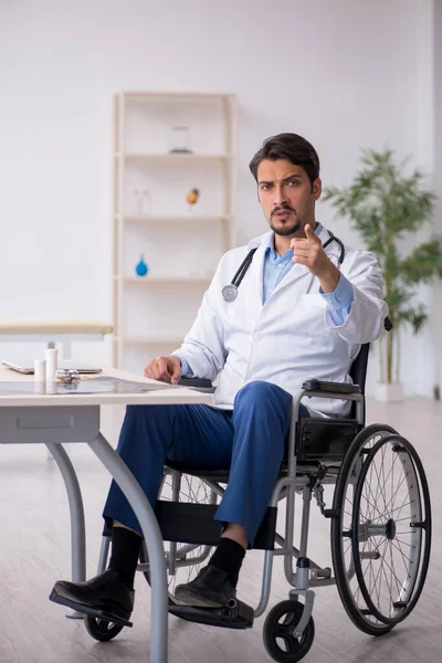 Junger Arzt im Rollstuhl arbeitet in der Klinik — Stockfoto