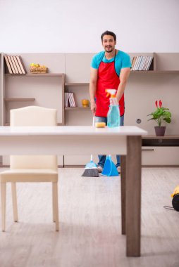 Genç erkek müteahhit evi temizliyor.