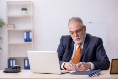 Ofiste çalışan yaşlı bir erkek.