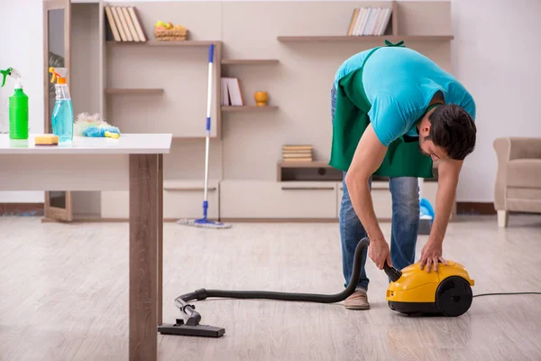 Jovem empreiteiro limpando a casa — Fotografia de Stock