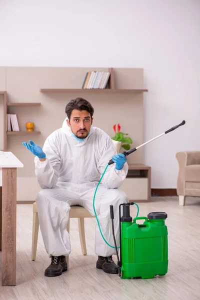 Young male contractor disinfecting at home — Φωτογραφία Αρχείου
