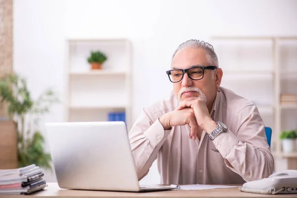 Alte männliche Mitarbeiter arbeiten am Arbeitsplatz — Stockfoto