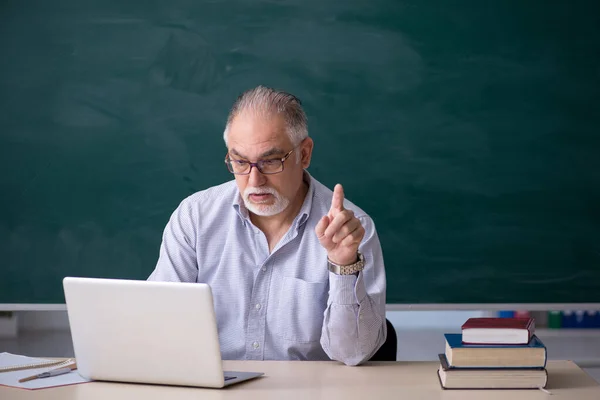 Viejo profesor delante del tablero verde — Foto de Stock