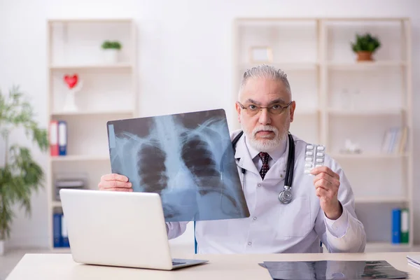 Velho médico radiologista trabalhando na clínica — Fotografia de Stock