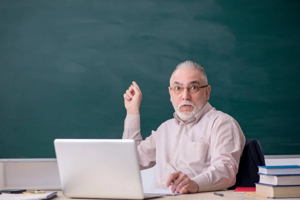 Oude mannelijke leraar voor schoolbord — Stockfoto