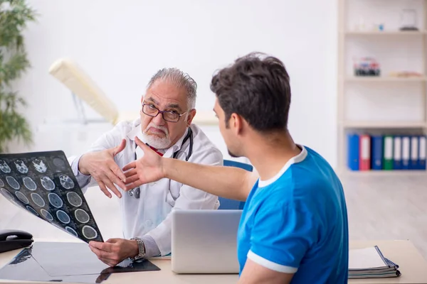 Paciente masculino joven que visita al radiólogo médico anciano —  Fotos de Stock