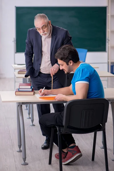 Velho professor e jovem estudante na frente do quadro negro — Fotografia de Stock