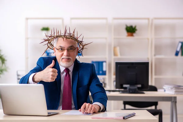 Alter männlicher Angestellter trägt stacheligen Kranz auf dem Kopf — Stockfoto