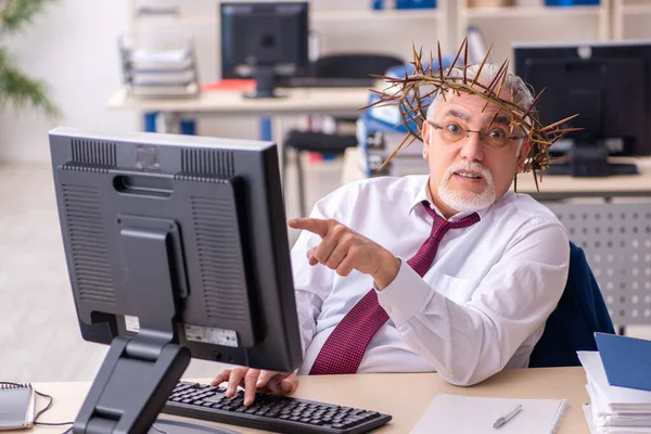 Alter männlicher Angestellter trägt stacheligen Kranz auf dem Kopf — Stockfoto