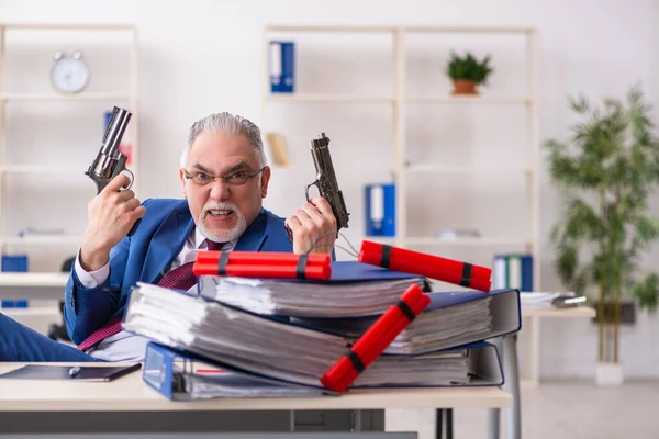 Gammal manlig anställd med dynamit på kontoret — Stockfoto