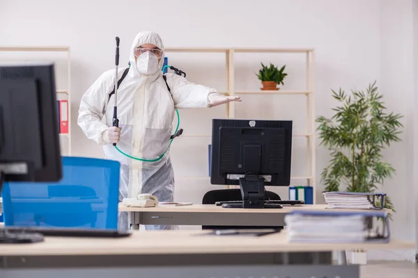 Old male contractor in office disinfection concept — Stock Photo, Image