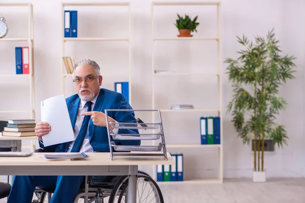 Stary mężczyzna pracownik na wózku inwalidzkim siedzi w biurze — Zdjęcie stockowe