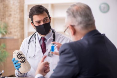 Yaşlı işadamı aşı danışmanıyla genç erkek doktoru ziyaret ediyor.