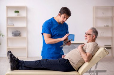 Yaşlı erkek hasta, genç doktor.