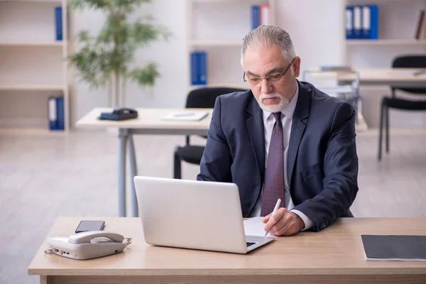 Ancien employé masculin assis sur le lieu de travail — Photo