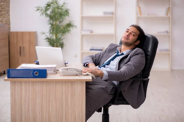 Jovem funcionário masculino infeliz com excesso de trabalho no escritório — Fotografia de Stock