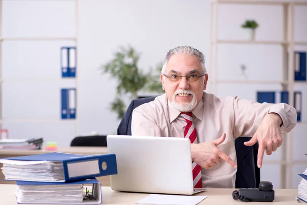 Old male employee sitting at workplace — Stock Photo, Image