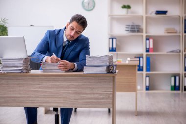 Genç işadamı ve ofiste çok fazla iş var.