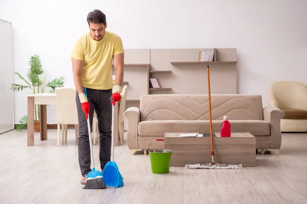 Νεαρός εργολήπτης καθαρίζει το σπίτι — Φωτογραφία Αρχείου