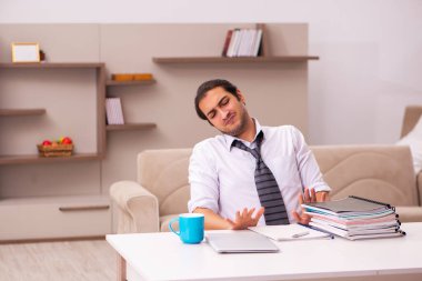 Genç erkek çalışan salgın sırasında evden çalışıyor.