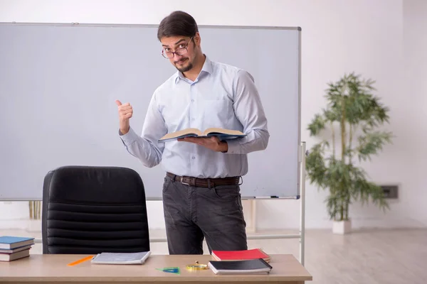 Jeune professeur masculin devant le tableau blanc — Photo